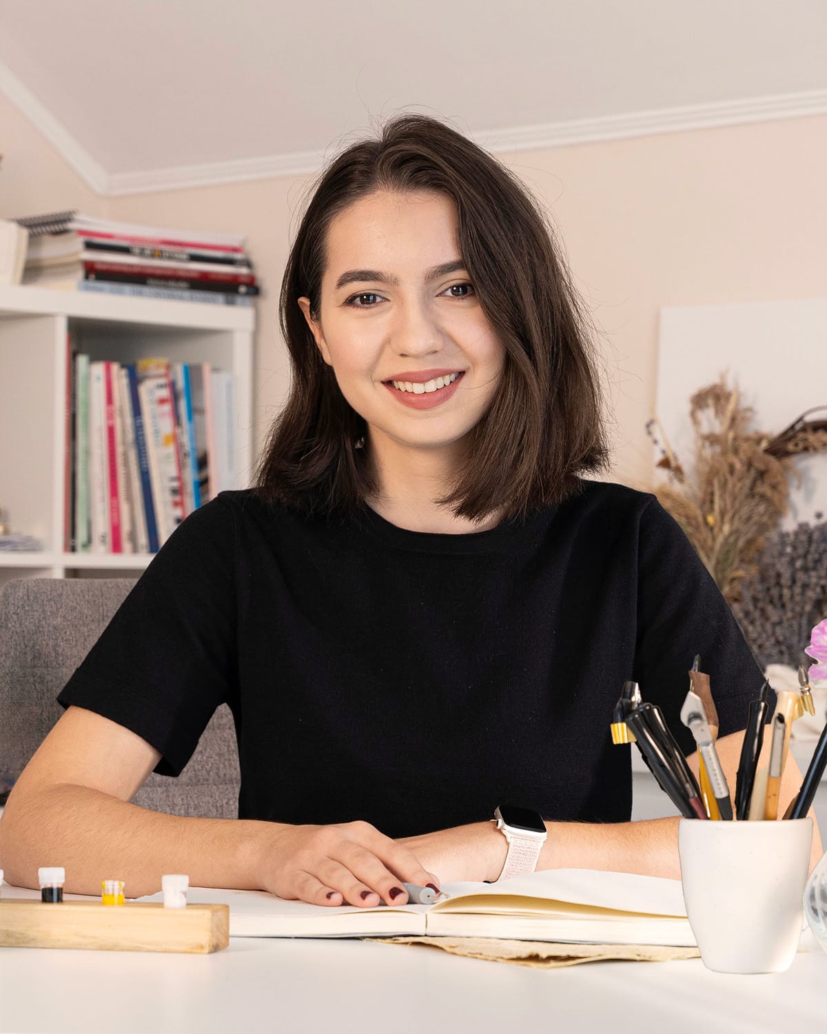 Denisa Micorici scriind caligrafie cu tocul și penița